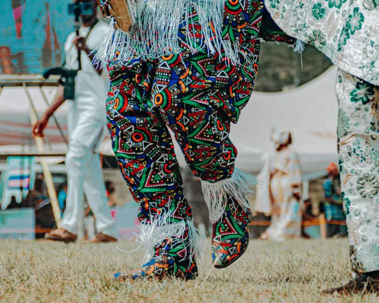 Traditional masquerade dancers in vibrant, colorful costumes at a cultural event in Nigeria.
