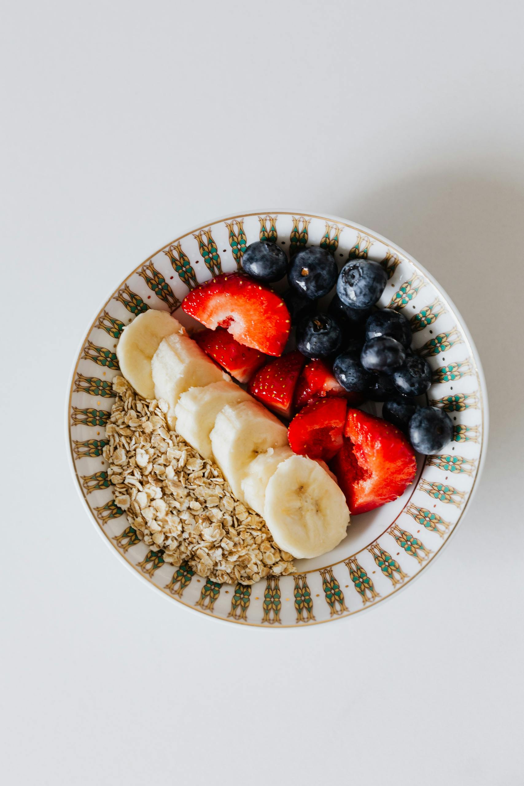 Top view of a bowl filled with fresh fruits and oats, perfect for a healthy and nutritious breakfast.